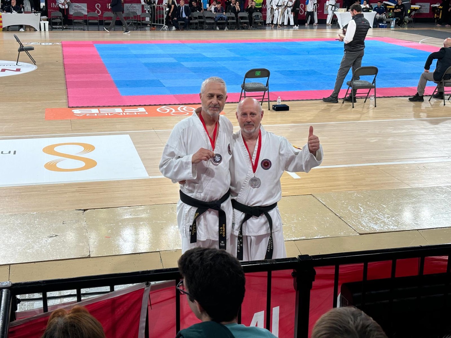 Dos competidores máster mostrando sus medallas