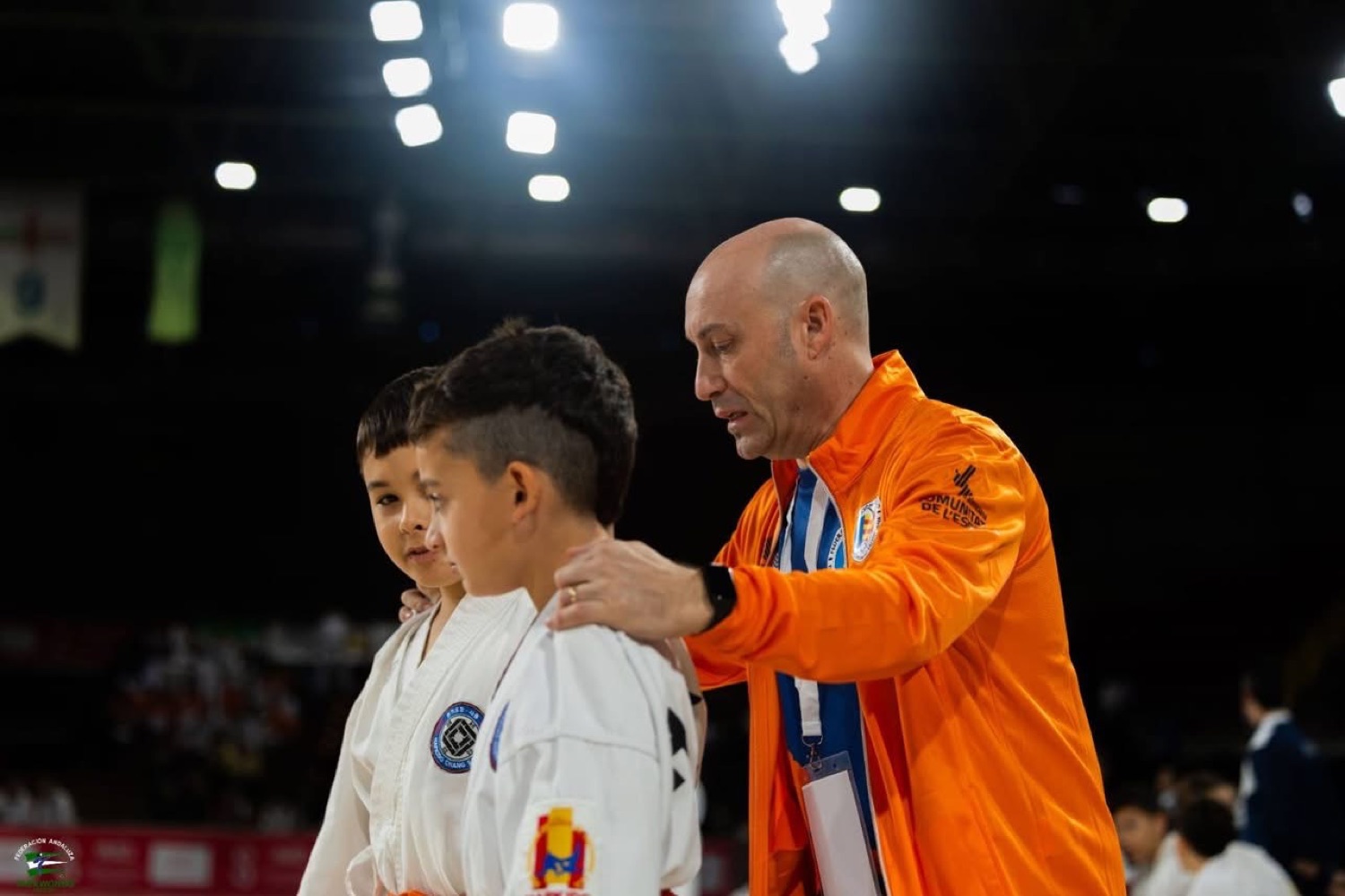 Entrenador acompañando a dos competidores infantiles antes de su ejercicio